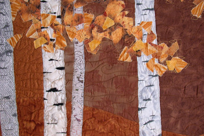 Image - golden leaves against brown background and white tree trunks